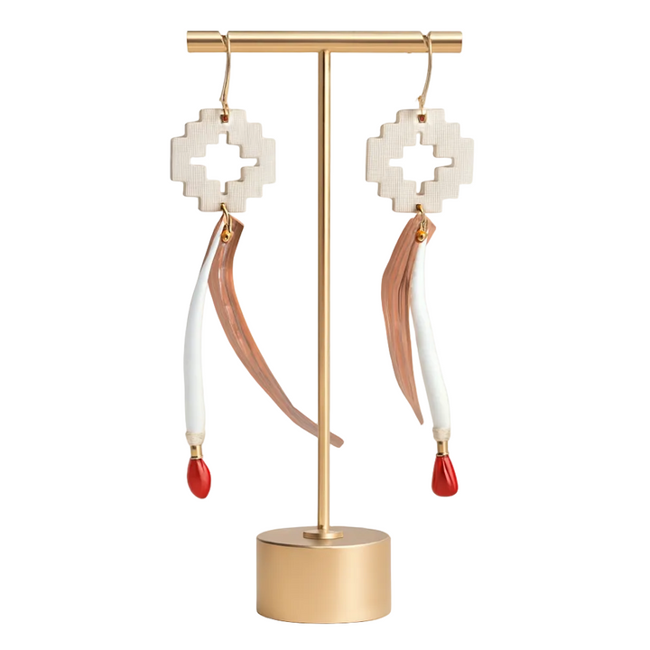 Pair of Native earrings on a gold stand with a white background