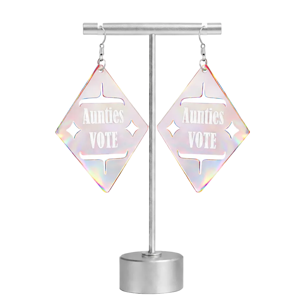Iridescent diamond-shaped earrings with 'Aunties Vote' text on a stand against a white background