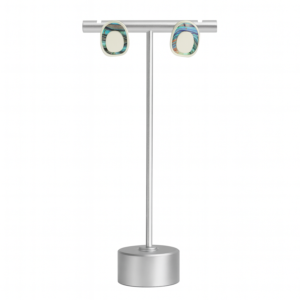 Pair of earrings on a silver stand against a white background