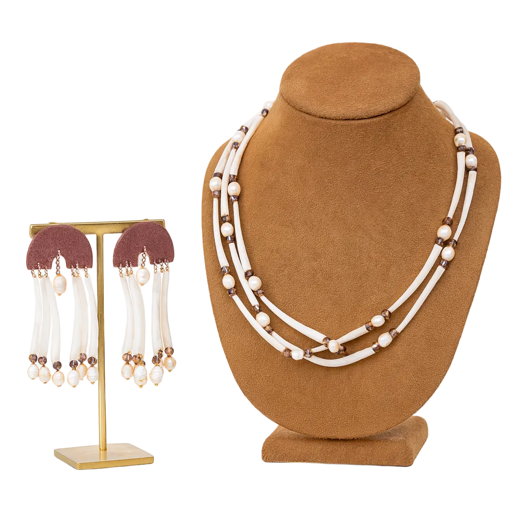 Necklace and earrings set on display stands against a white background