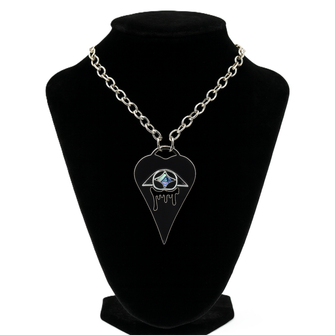Necklace with a pendant on a black stand against a white background