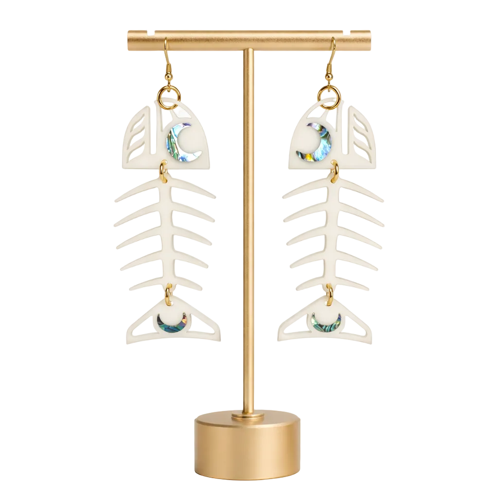 White fish bone-shaped earrings on a gold stand against a white background