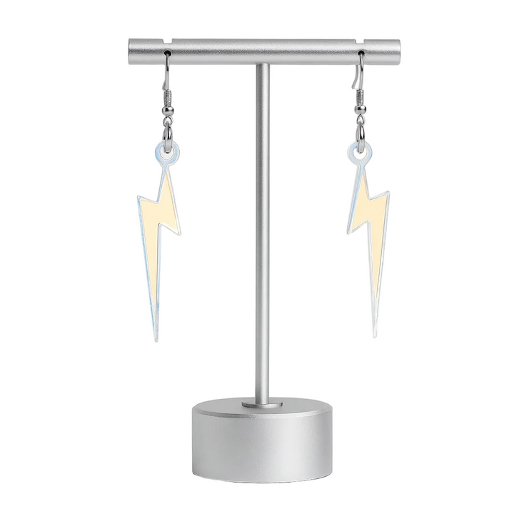 Pair of lightning bolt earrings on a stand against a white background
