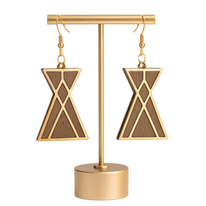 Wooden tipi earrings on a gold stand against a white background
